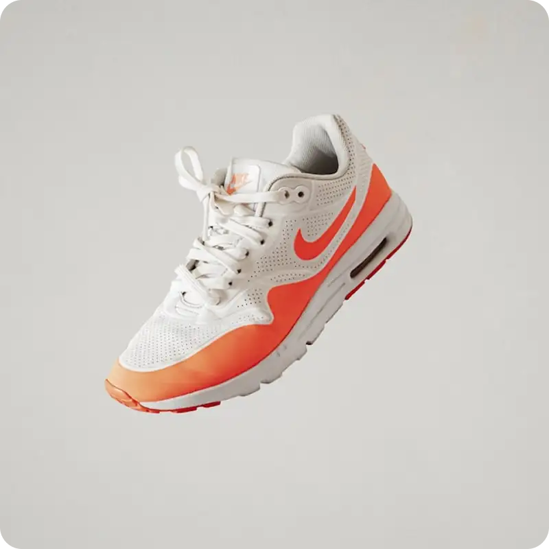 White and orange Nike sneaker on a light background